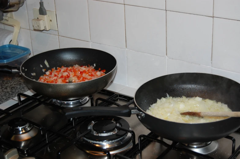 two pans are on the stove with food in them