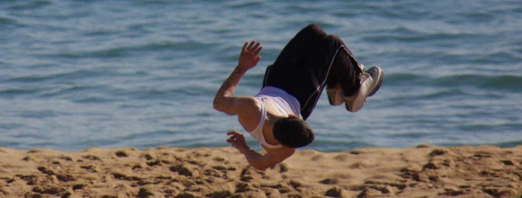 a man falling on the beach after surfing