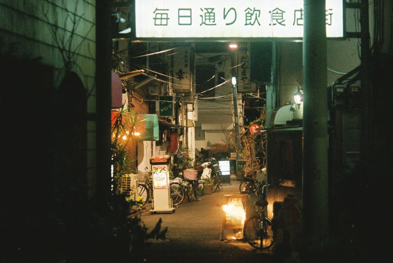 an alley way with many people and buildings at night