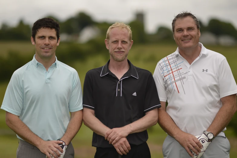 three men wearing black and white shirts standing next to each other