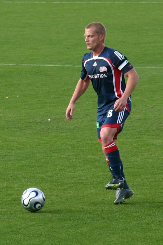 a man in a blue soccer uniform is playing soccer