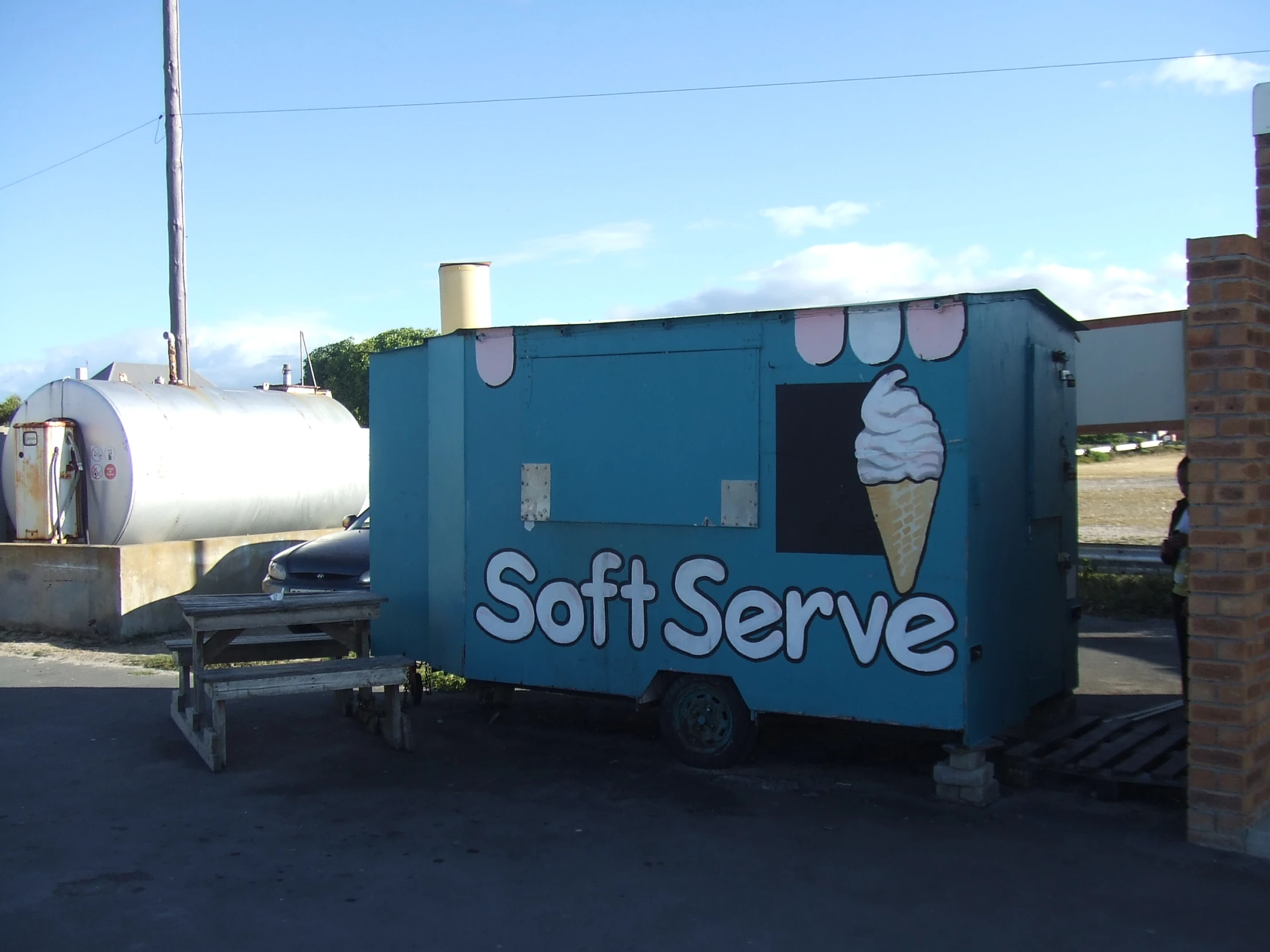 a blue ice cream truck is parked in a parking lot