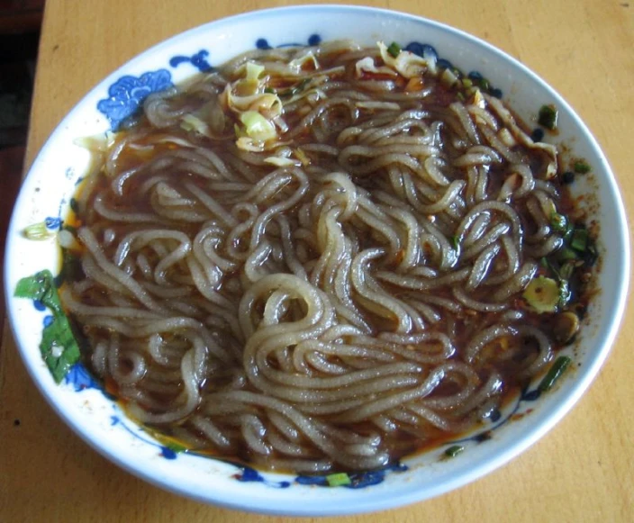 a plate of noodles and noodle sauce in a bowl