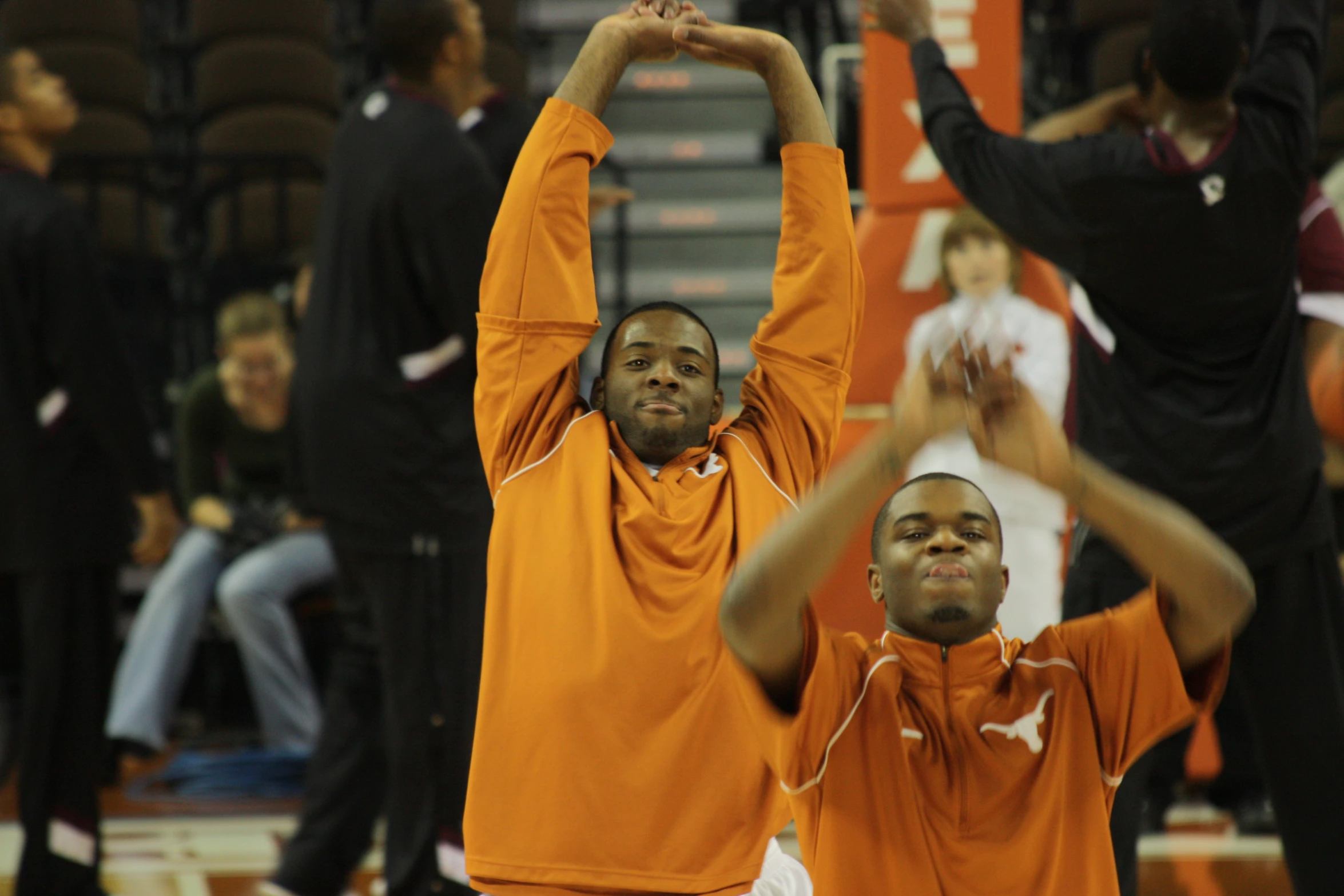 two men holding their hands up in victory for a basketball game