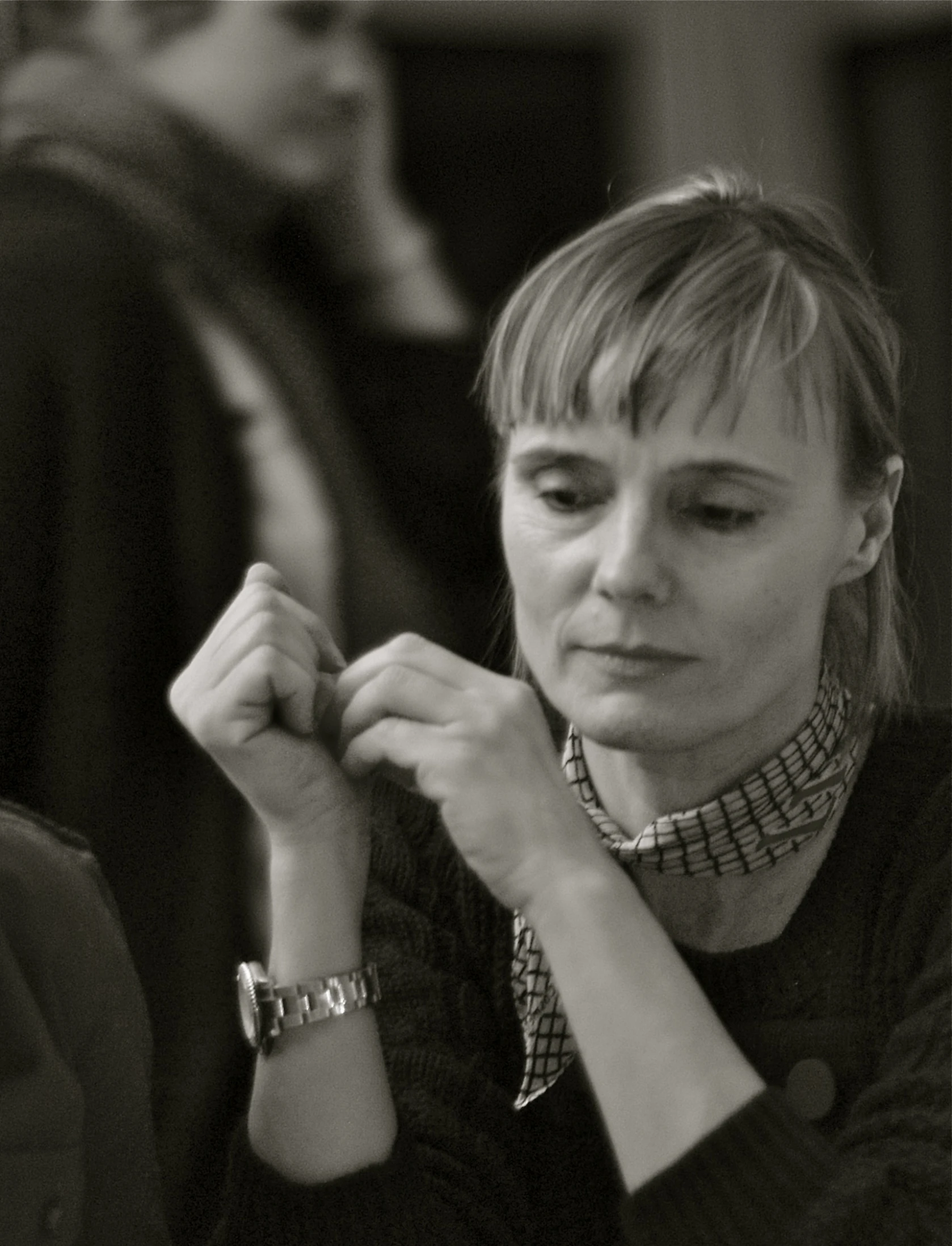 a woman holding on to her neck while sitting down