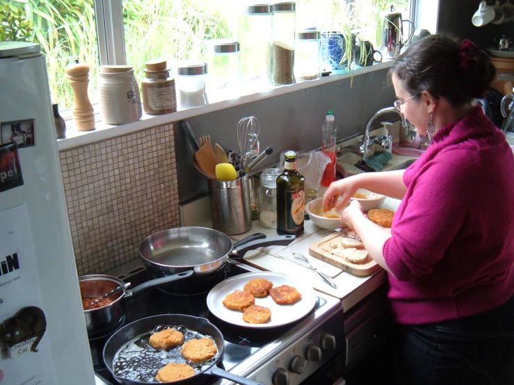 a lady is preparing food on top of a stove