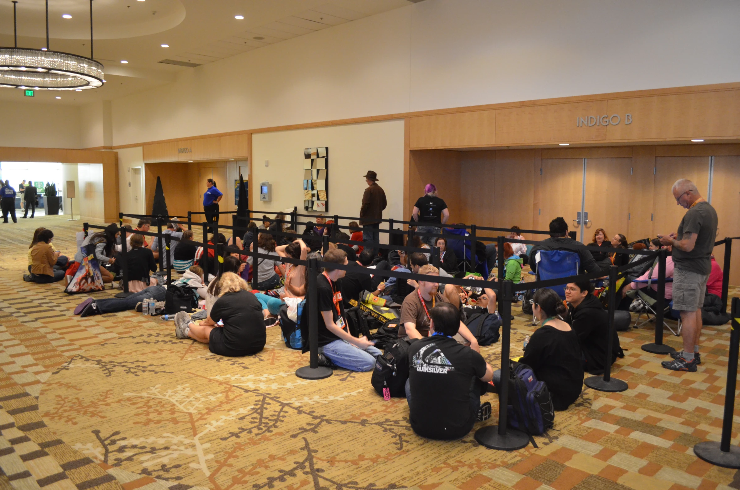 many children sit and stand on the floor in a waiting area