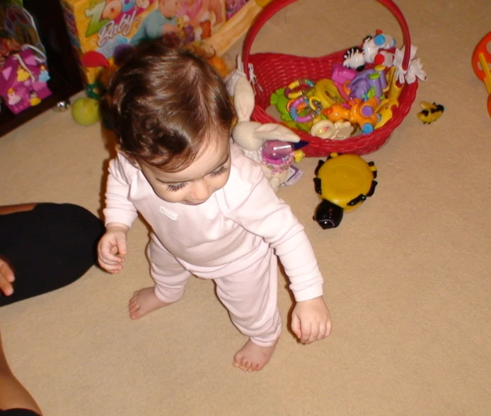 a toddler girl is in a playroom playing with toys