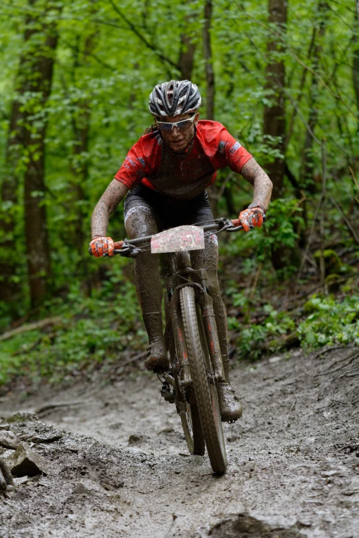 a man riding a bicycle on top of a muddy hillside