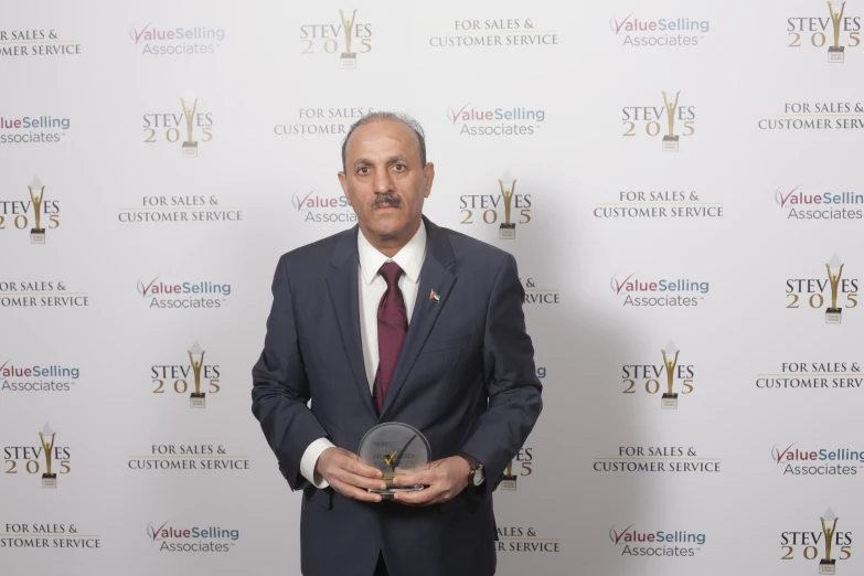 a man in a suit and tie holding an award