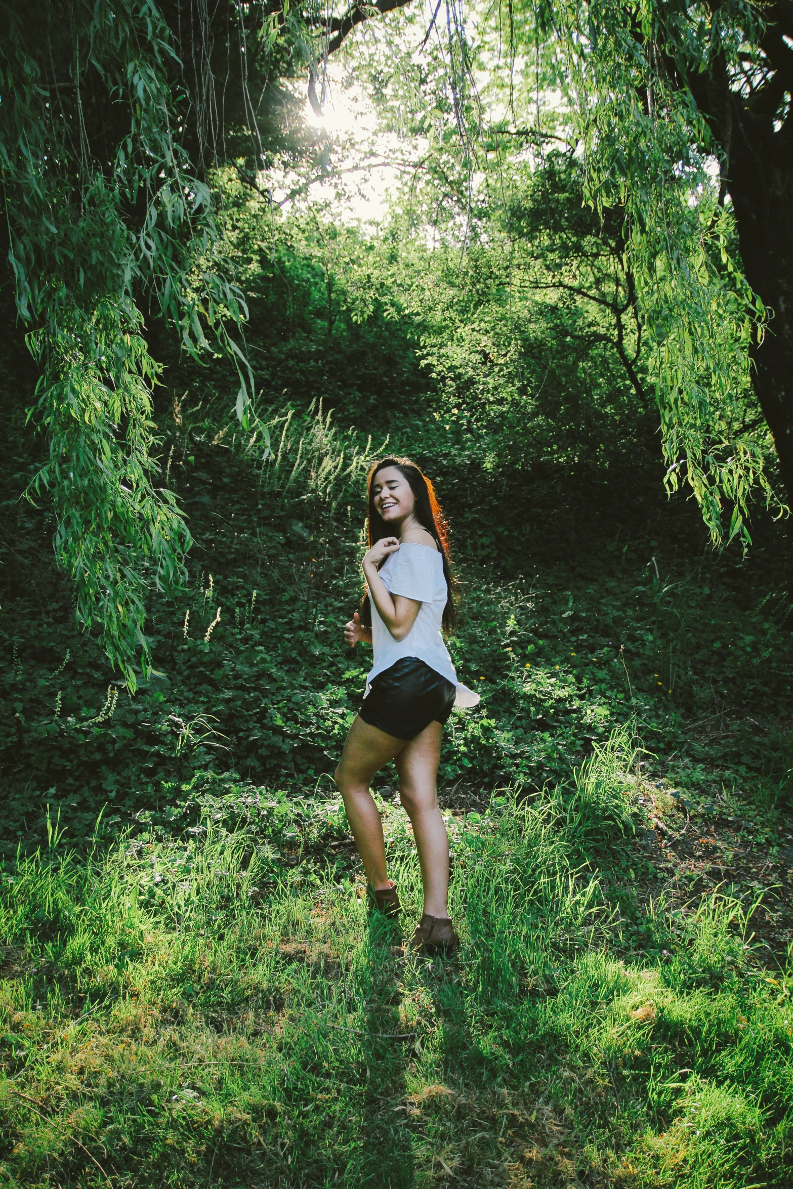 a girl is in a field playing with a tennis racket