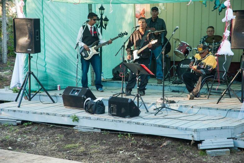 people are on a stage that contains guitars