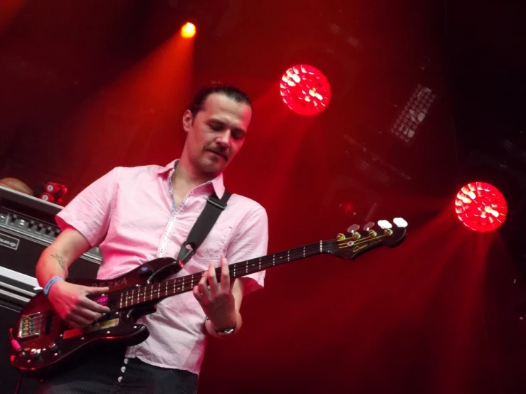 a man is playing his guitar on the stage