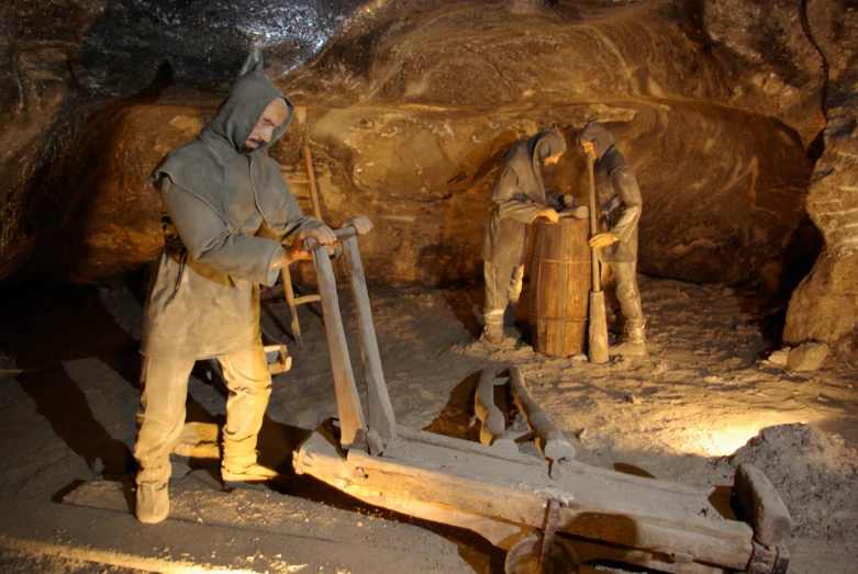 two statues in a cave setting with lights on
