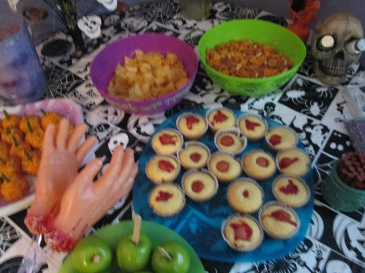 a table full of bowls and food and hands that are placed