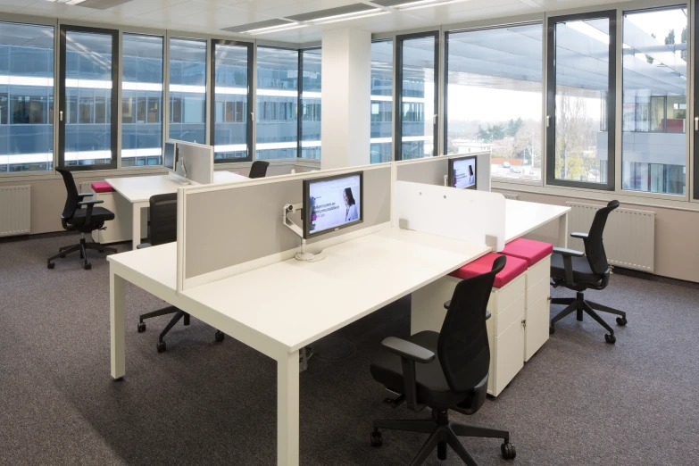 two open desks sit next to each other in an empty office