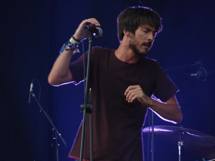 a man is singing into a microphone at a concert