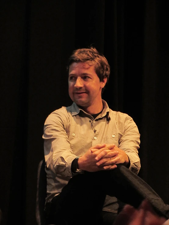 a man sitting in a chair and smiling