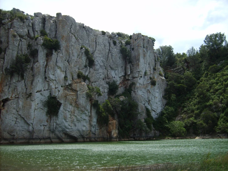 a green body of water near a large mountain