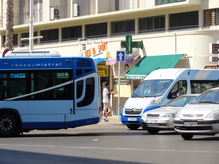 a bus passing through a parking lot in front of an apartment building