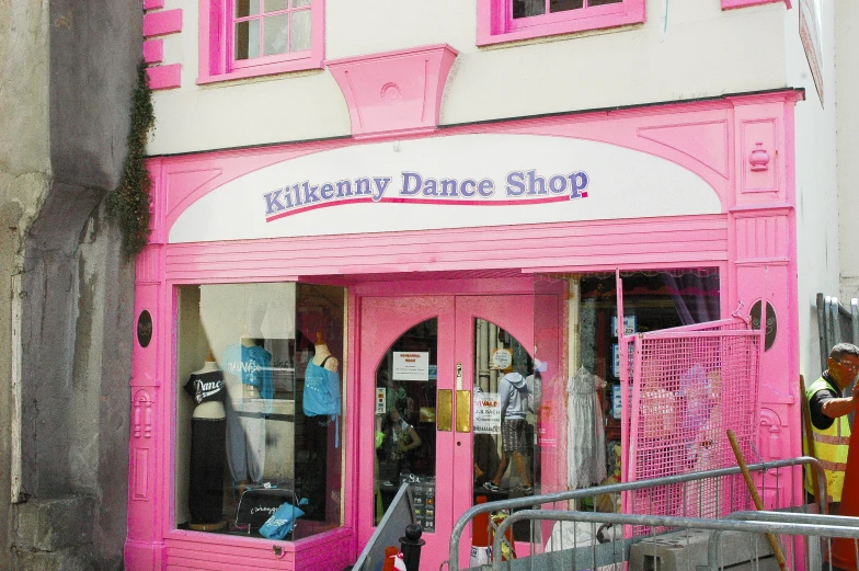 a pink storefront with people standing outside it