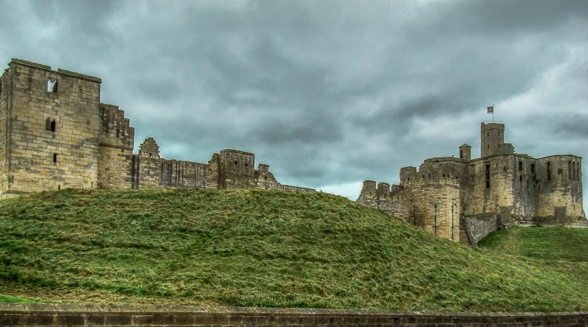 a very tall castle next to a lush green field