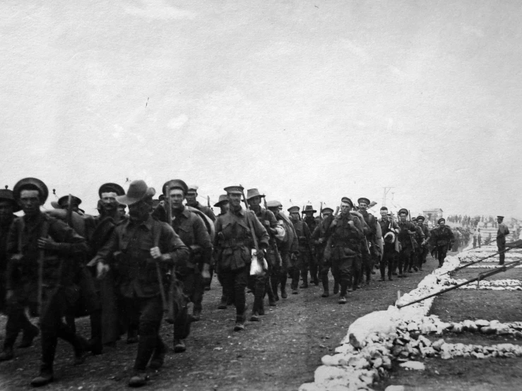 men in military uniforms walking through snow