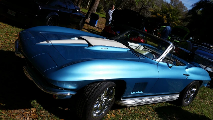 the front end of a classic blue sports car