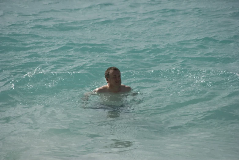 a man swims in the ocean with  on