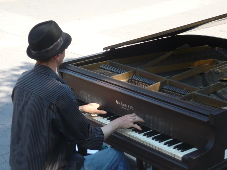 a man playing a piano on the street