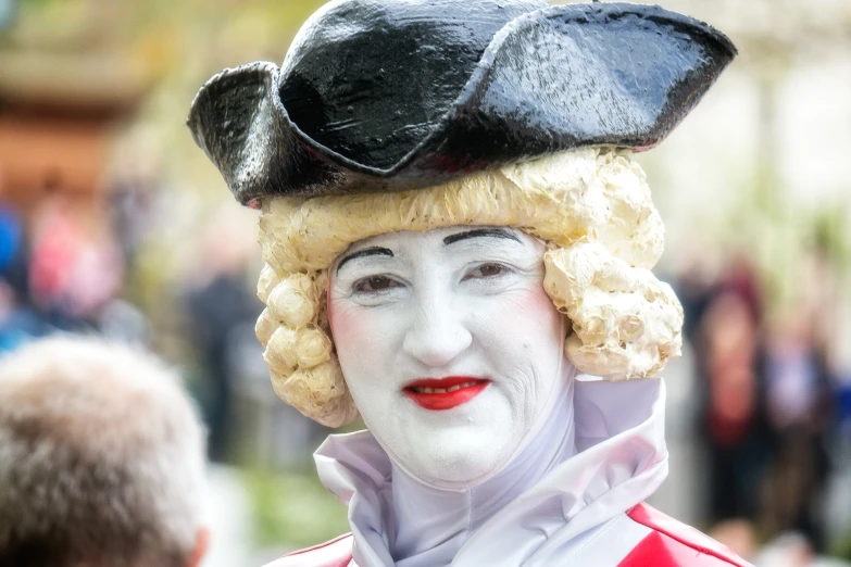 a woman with white makeup is dressed in a costume