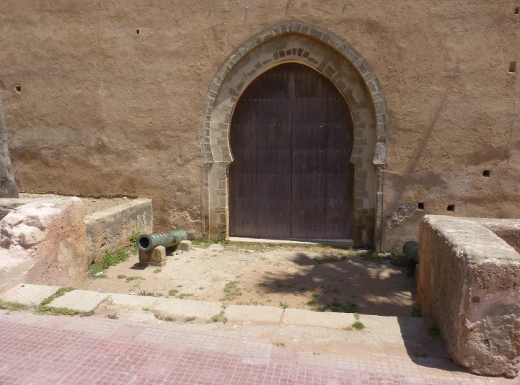 an old wall with a door and bench in the middle of it