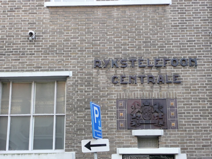 a red brick building with a sign and a street name on the front of it