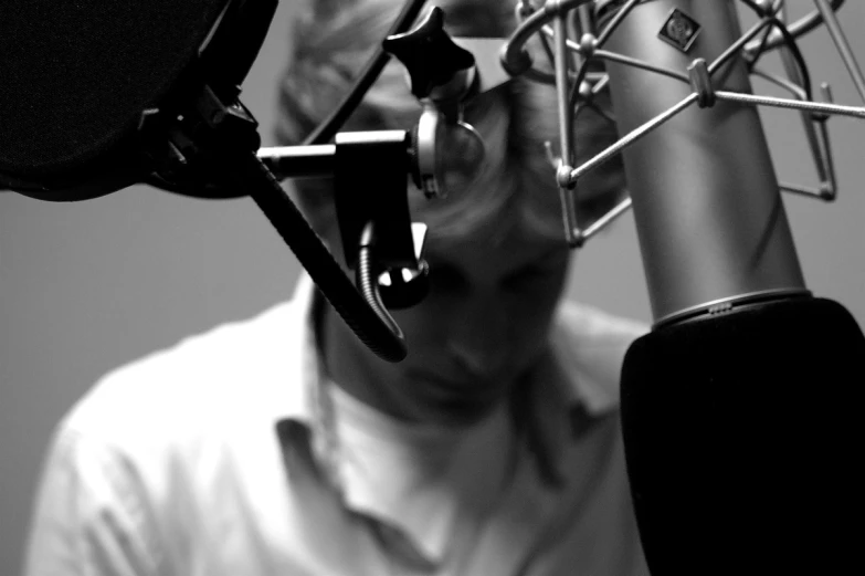 a man wearing a shirt and glasses in a radio studio