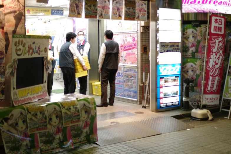 a group of three men looking at posters outside of a shop