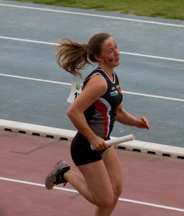 a woman is running on the track and smiling