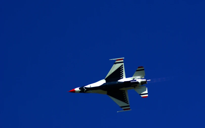 a white and red fighter jet flying across the air