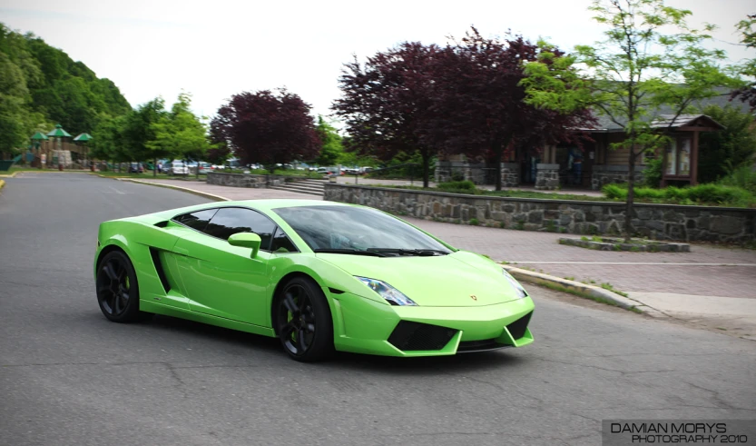 a very nice green car is on the road