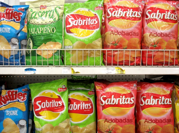 several bags of snacks are on shelves in a store