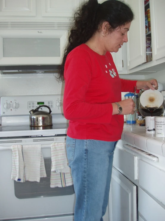 a woman is standing at a sink mixing soing