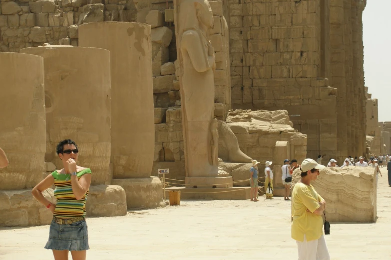 two women in front of statues of ancient egyptian architecture