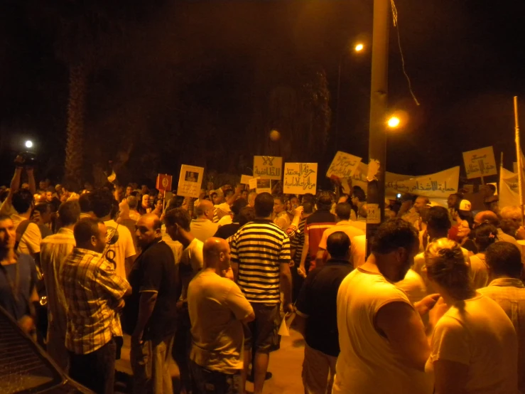 the group of protesters are marching outside in the dark