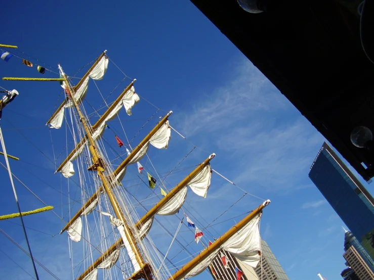 a large mast sailing ship with lots of white sail cloths