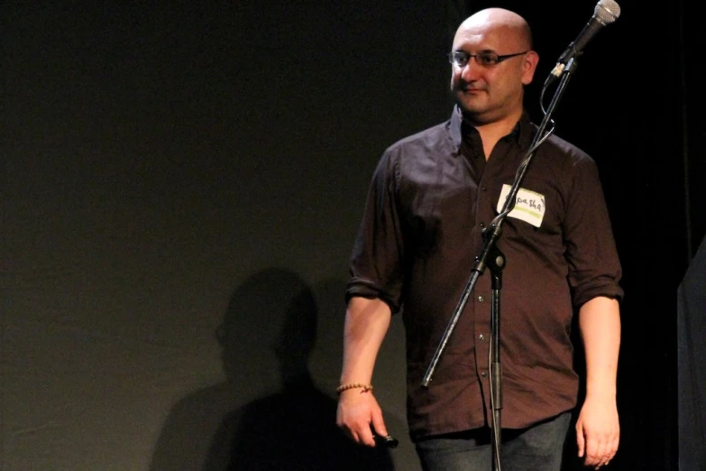 a man standing in front of a microphone holding a mic