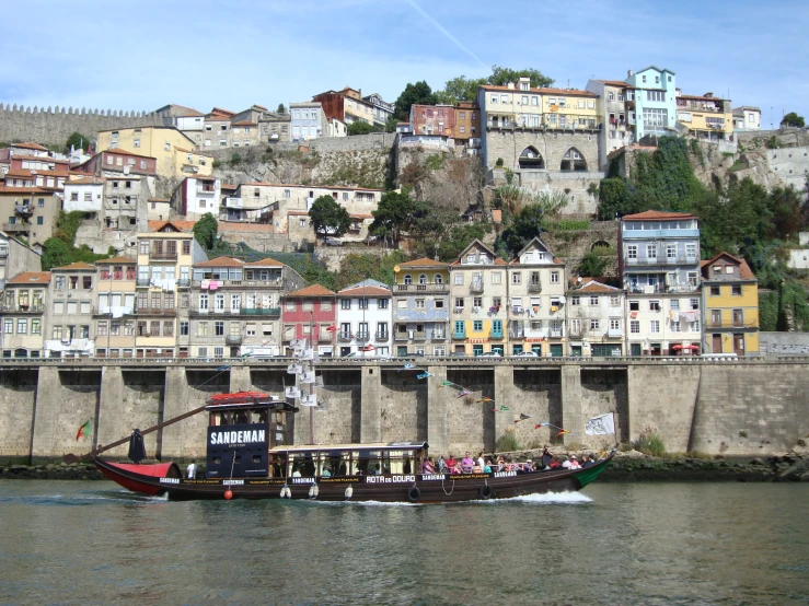 a boat traveling along a river in front of a city