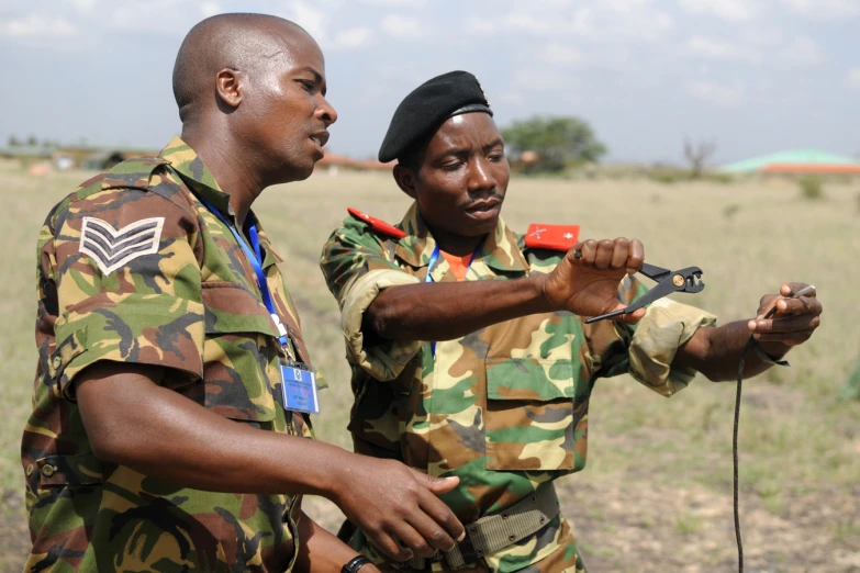 two african american soldiers are using tools to record a land