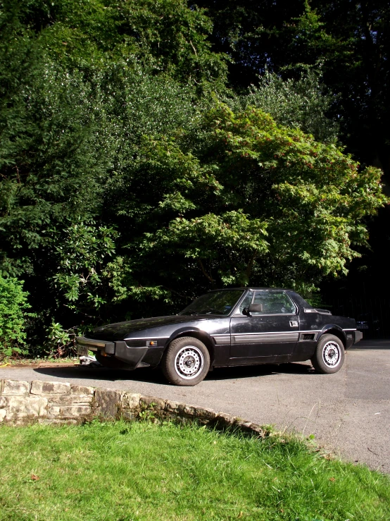 a black car sits parked on a road