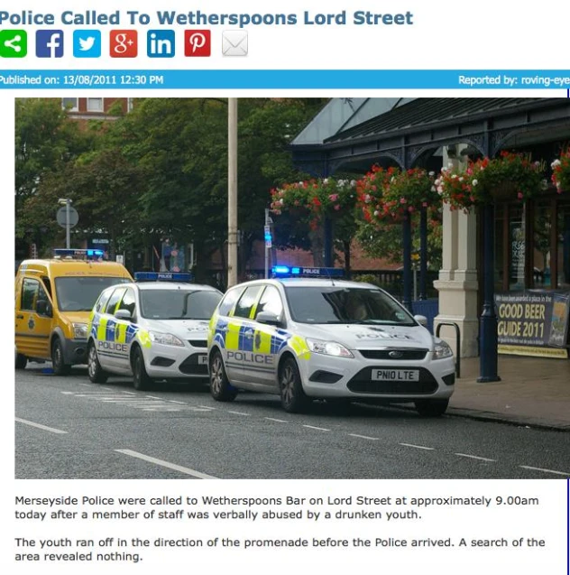 a newspaper article about two police cars driving down the street