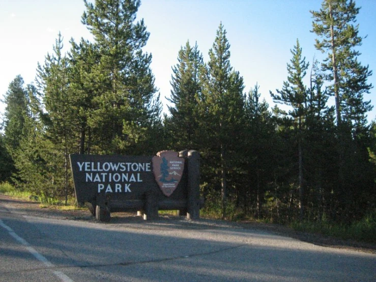 the yellow stone national park sign sits in front of the trees