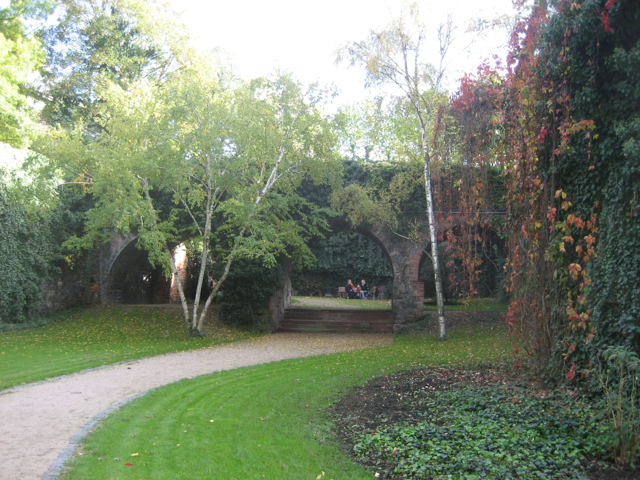 people are walking along the path near the woods